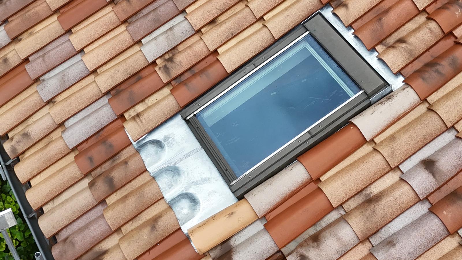 Fenêtre de toit et son raccord zinc dans une toiture en tuiles